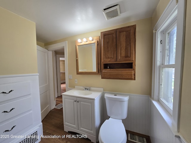 812 Westmoreland Ave, Lansing, MI 48915 - bathroom featuring vanity, toilet, wainscoting, and wood finished floors