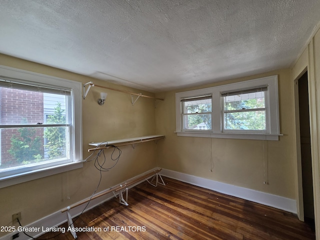 812 Westmoreland Ave, Lansing, MI 48915 - spare room featuring hardwood / wood-style flooring, a textured ceiling, and baseboards