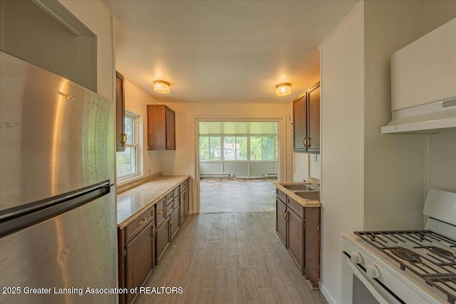 629 Emily Ave, Lansing, MI 48910 - kitchen with freestanding refrigerator, gas range gas stove, light countertops, light wood-style floors, and a sink