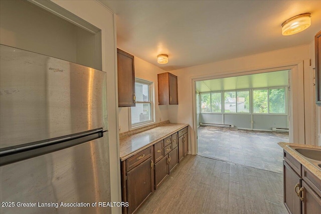 629 Emily Ave, Lansing, MI 48910 - kitchen featuring freestanding refrigerator, a baseboard radiator, healthy amount of natural light, and light countertops