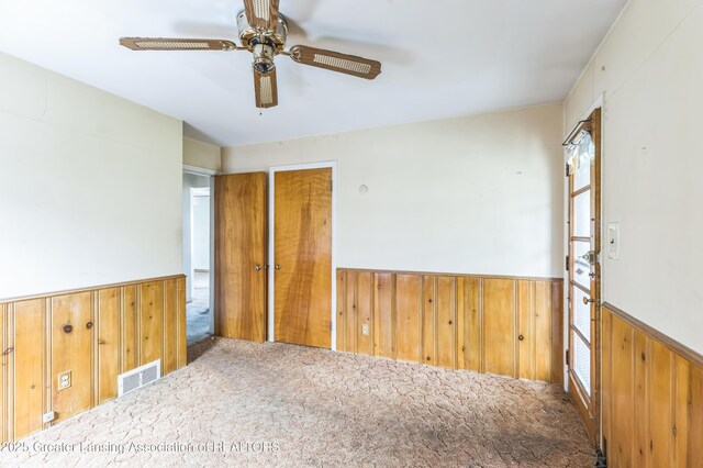 19326 Marlowe St, Detroit, MI 48235 - spare room with wooden walls, a wainscoted wall, carpet floors, and a ceiling fan