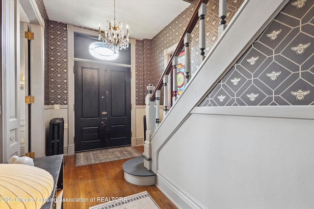 1035 N Capitol Ave, Lansing, MI 48906 - entrance foyer featuring wallpapered walls, wood finished floors, a chandelier, and stairway