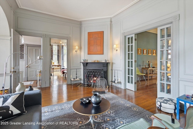 1035 N Capitol Ave, Lansing, MI 48906 - living room with french doors, a decorative wall, ornamental molding, wood finished floors, and a fireplace with flush hearth