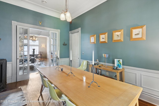 1035 N Capitol Ave, Lansing, MI 48906 - dining room with a decorative wall, crown molding, a wainscoted wall, wood finished floors, and a chandelier