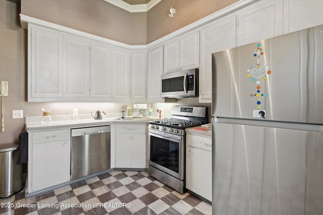 1035 N Capitol Ave, Lansing, MI 48906 - kitchen featuring stainless steel appliances, light countertops, white cabinetry, crown molding, and tile patterned floors