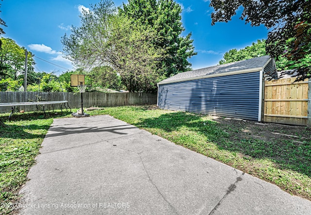 3701 Jerree St, Lansing, MI 48911 - fenced backyard featuring a trampoline, a patio, and an outbuilding