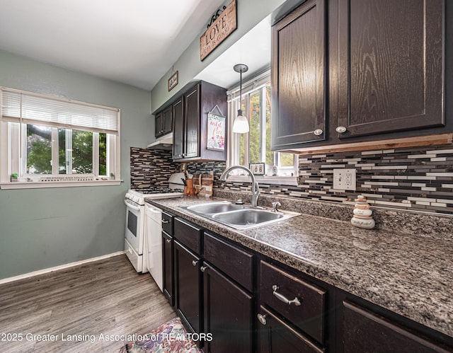 3701 Jerree St, Lansing, MI 48911 - kitchen featuring decorative backsplash, dark countertops, white gas range oven, dark brown cabinetry, and wood finished floors