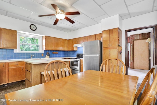8767 Corrison Rd, Grand Ledge, MI 48837 - kitchen featuring stainless steel appliances, light countertops, under cabinet range hood, ceiling fan, and backsplash