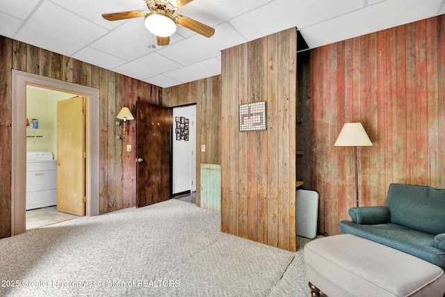 8767 Corrison Rd, Grand Ledge, MI 48837 - living area with washer / dryer, wood walls, carpet, a ceiling fan, and a paneled ceiling
