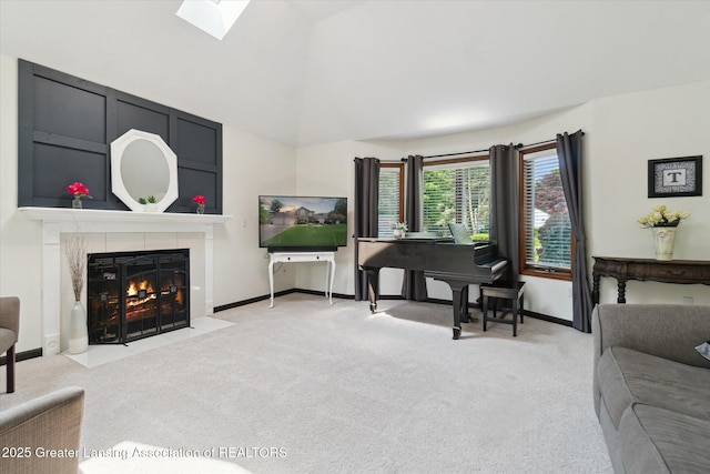 2020 Sunset Dr, Owosso, MI 48867 - living room featuring light colored carpet, a tiled fireplace, a skylight, and vaulted ceiling