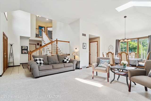 2020 Sunset Dr, Owosso, MI 48867 - living area featuring high vaulted ceiling, a skylight, light colored carpet, a chandelier, and stairs