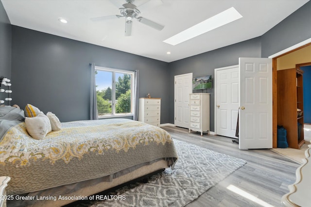 2020 Sunset Dr, Owosso, MI 48867 - bedroom featuring a skylight, wood finished floors, ceiling fan, recessed lighting, and lofted ceiling