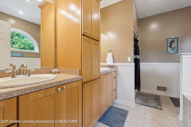 2020 Sunset Dr, Owosso, MI 48867 - full bathroom with double vanity, wainscoting, and tile patterned flooring