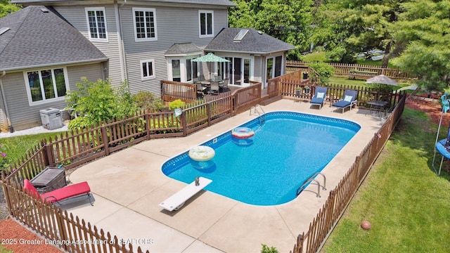 2020 Sunset Dr, Owosso, MI 48867 - view of pool featuring a diving board, a wooden deck, a patio area, a fenced backyard, and outdoor dining space