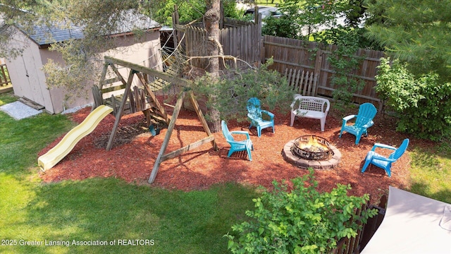 2020 Sunset Dr, Owosso, MI 48867 - view of jungle gym featuring a fire pit and a shed