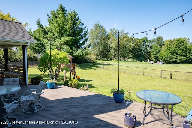 10464 Hankerd Rd, Pleasant Lake, MI 49272 - wooden deck with a playground, a fenced backyard, and view of wooded area