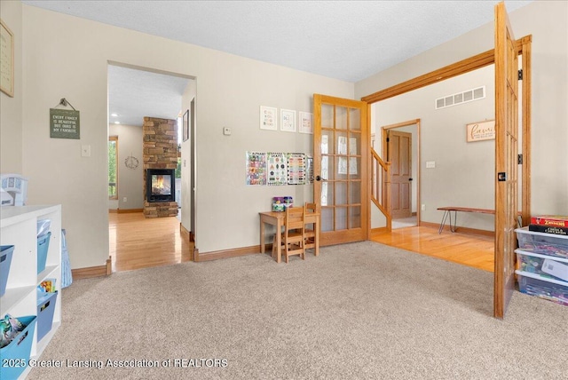 4905 E Green Rd, Saint Johns, MI 48879 - interior space featuring carpet flooring, a stone fireplace, and french doors