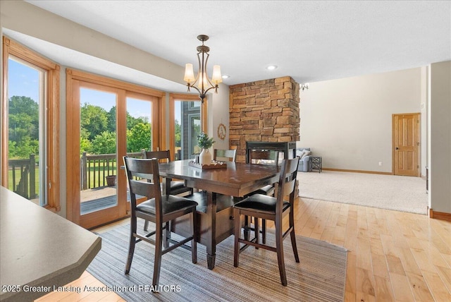 4905 E Green Rd, Saint Johns, MI 48879 - dining space featuring light wood-style floors, a fireplace, a chandelier, and recessed lighting