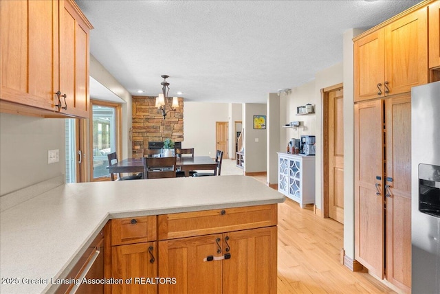 4905 E Green Rd, Saint Johns, MI 48879 - kitchen featuring stainless steel fridge with ice dispenser, a peninsula, a textured ceiling, light wood-style floors, and light countertops