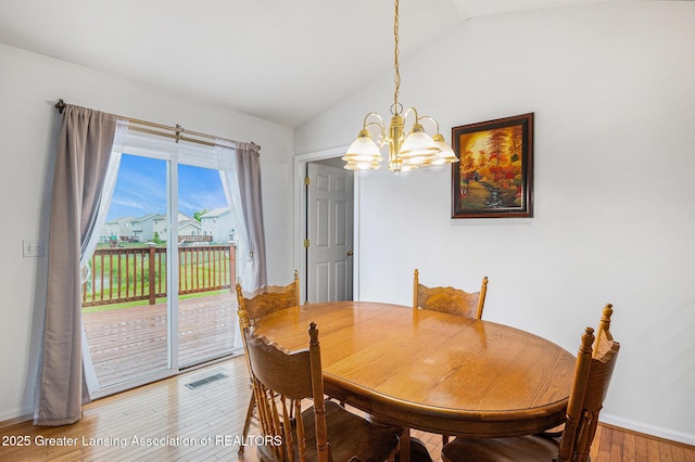 1262 Evans St, Mason, MI 48854 - dining room with a chandelier, light wood finished floors, and vaulted ceiling