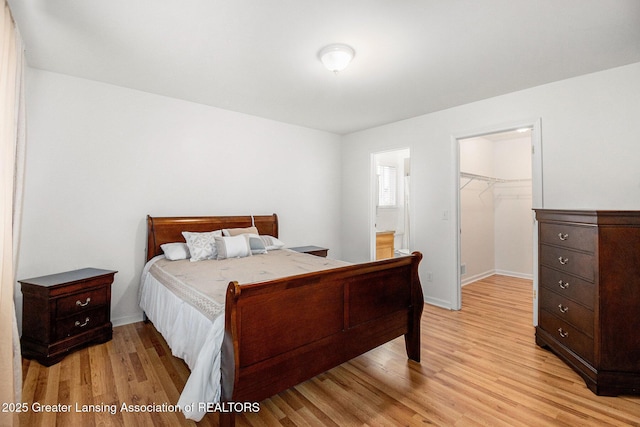 1262 Evans St, Mason, MI 48854 - bedroom featuring light wood-type flooring, a spacious closet, a closet, and ensuite bathroom