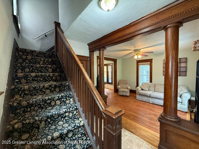 921 W Genesee St, Lansing, MI 48915 - stairway with a ceiling fan, ornate columns, and beamed ceiling