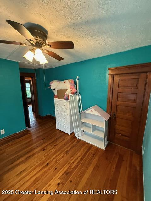 921 W Genesee St, Lansing, MI 48915 - bedroom featuring a textured ceiling, wood finished floors, and ceiling fan