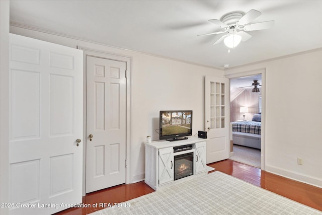 350 N Marshall Ave, Marshall, MI 49068 - bedroom with dark wood-style flooring, a glass covered fireplace, a ceiling fan, and ornamental molding