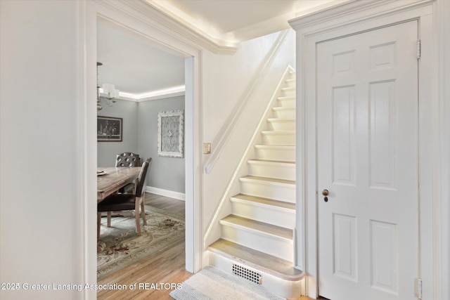 350 N Marshall Ave, Marshall, MI 49068 - stairway with wood finished floors, a chandelier, and crown molding