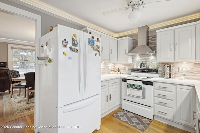 350 N Marshall Ave, Marshall, MI 49068 - kitchen featuring white appliances, wall chimney range hood, light wood finished floors, tasteful backsplash, and ornamental molding