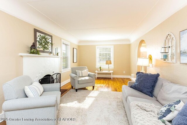 720 N Fairview Ave, Lansing, MI 48912 - living room with wood finished floors, arched walkways, and a tile fireplace
