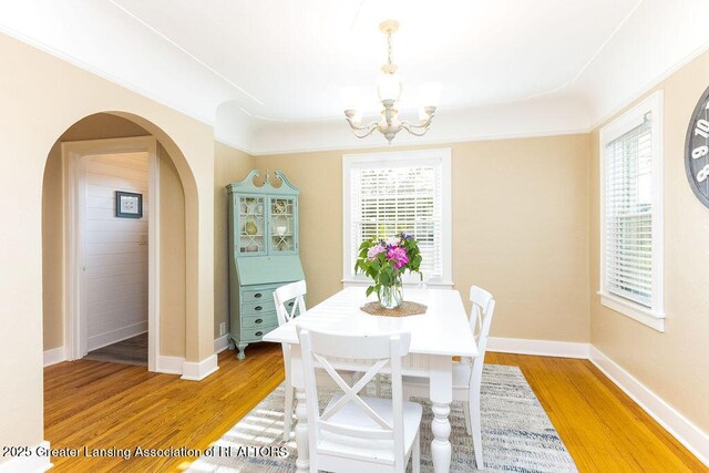 720 N Fairview Ave, Lansing, MI 48912 - dining room featuring a chandelier, light wood-type flooring, and arched walkways