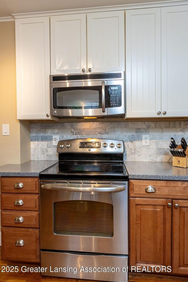 720 N Fairview Ave, Lansing, MI 48912 - kitchen featuring stainless steel appliances, tasteful backsplash, white cabinetry, brown cabinets, and ornamental molding