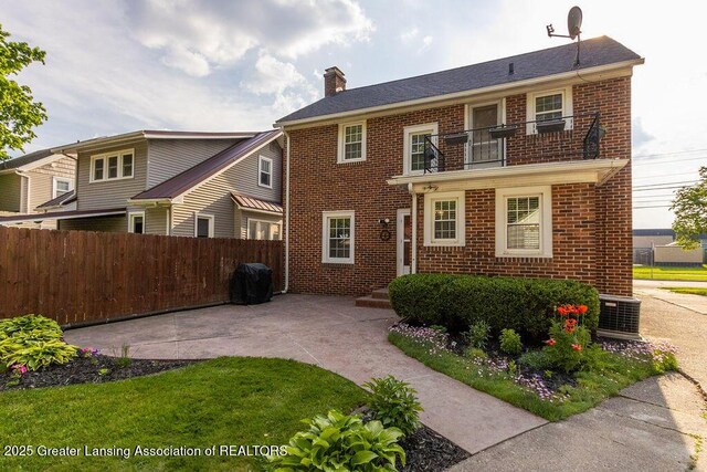 720 N Fairview Ave, Lansing, MI 48912 - view of front of home featuring a balcony, brick siding, a chimney, and a patio