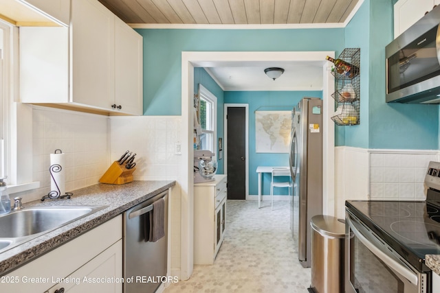 515 N Fairview Ave, Lansing, MI 48912 - kitchen with appliances with stainless steel finishes, ornamental molding, white cabinetry, light floors, and wood ceiling