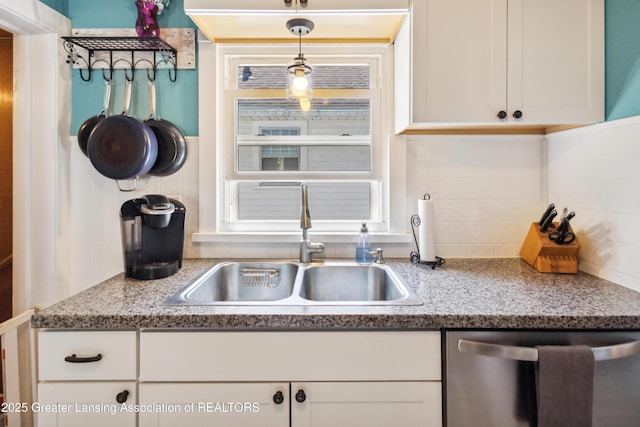 515 N Fairview Ave, Lansing, MI 48912 - kitchen with stainless steel dishwasher, backsplash, white cabinetry, and decorative light fixtures