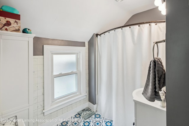 515 N Fairview Ave, Lansing, MI 48912 - bathroom featuring lofted ceiling, tile patterned flooring, and a shower with shower curtain