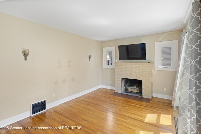 2335 Harding Ave, Lansing, MI 48910 - unfurnished living room featuring wood finished floors and a brick fireplace