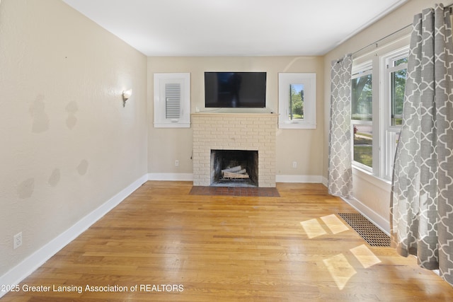 2335 Harding Ave, Lansing, MI 48910 - unfurnished living room featuring light wood-type flooring and a fireplace