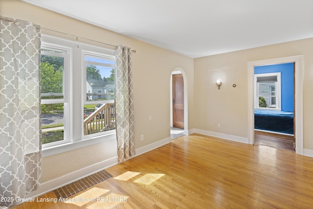 2335 Harding Ave, Lansing, MI 48910 - empty room with arched walkways and wood finished floors