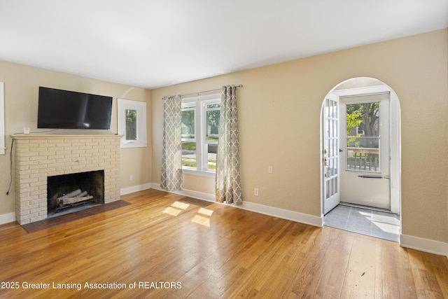 2335 Harding Ave, Lansing, MI 48910 - unfurnished living room featuring light wood-style flooring and a brick fireplace