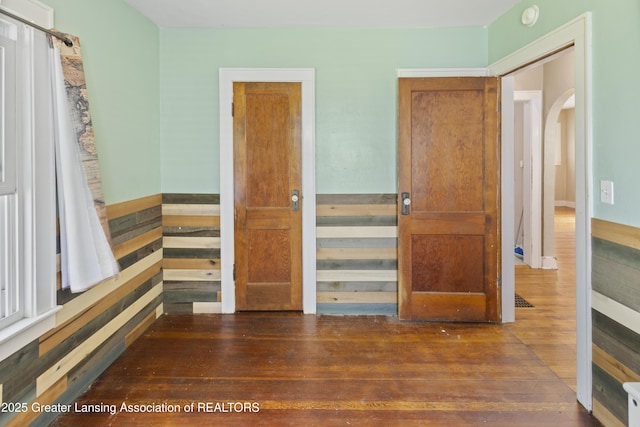 2335 Harding Ave, Lansing, MI 48910 - unfurnished bedroom featuring arched walkways and wood-type flooring