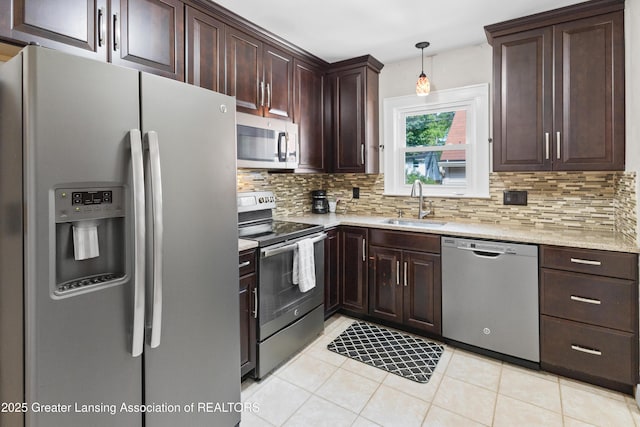 2335 Harding Ave, Lansing, MI 48910 - kitchen with stainless steel appliances, backsplash, light tile patterned flooring, and dark brown cabinets