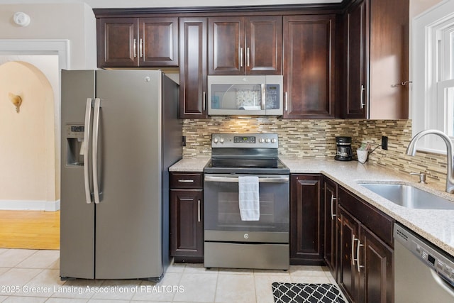 2335 Harding Ave, Lansing, MI 48910 - kitchen featuring stainless steel appliances, light tile patterned flooring, tasteful backsplash, and dark brown cabinets