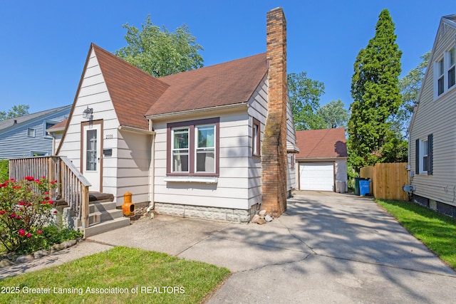 2335 Harding Ave, Lansing, MI 48910 - bungalow-style home with a detached garage, a chimney, and roof with shingles