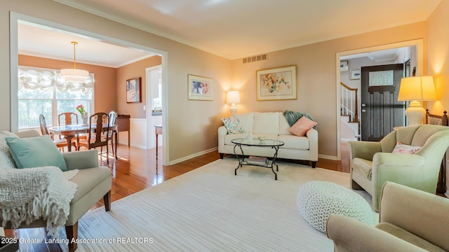 5939 Highgate Ave, East Lansing, MI 48823 - living area with wood finished floors, crown molding, stairs, and a chandelier