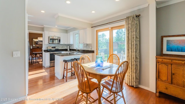 5939 Highgate Ave, East Lansing, MI 48823 - dining room with light wood-style floors, recessed lighting, and crown molding