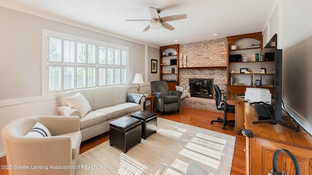 5939 Highgate Ave, East Lansing, MI 48823 - living area with ceiling fan, light wood-style flooring, a fireplace, and built in features