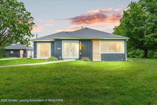 3707 W Michigan Ave, Lansing, MI 48917 - back of house with french doors, board and batten siding, and a yard