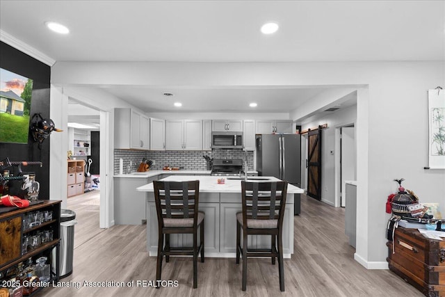 3707 W Michigan Ave, Lansing, MI 48917 - kitchen featuring appliances with stainless steel finishes, gray cabinets, light countertops, tasteful backsplash, and light wood-style flooring